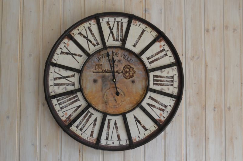 Retro hodiny s rímskymi číslicami na drevenej stene